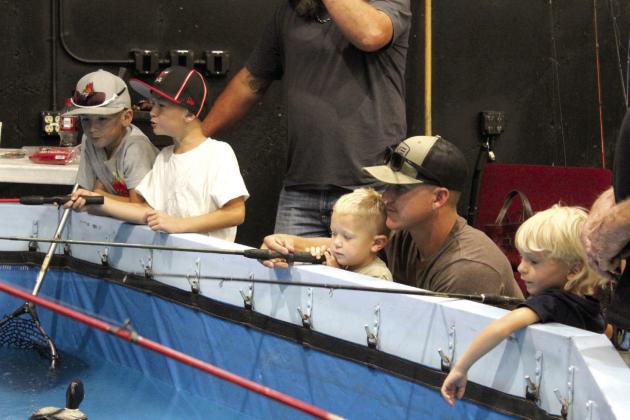 Four boys practice fishing for catfish at the ArmyBassAnglers Fishing Tank during the Outdoor Network Expo at FireLake Arena on Aug. 9.