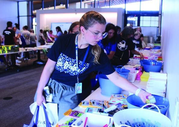 Eja Collier, a Shawnee High School Visual Arts teacher, adds pencil sharpeners to her bag during the Pack the School event for teachers to stock up on school supplies, held at First United in Shawnee on Aug. 8. Natasha Dunagan, Countywide &amp; Sun