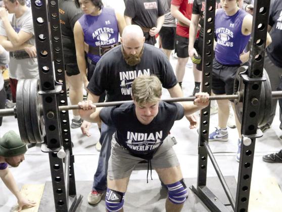 Asher Head Powerlifting Coach Bobby Carnes spots for senior Brogan Culwell as he does squat lifts. Culwell is the first person at Asher to join the “1,000-Pound Club.” Photo provided.