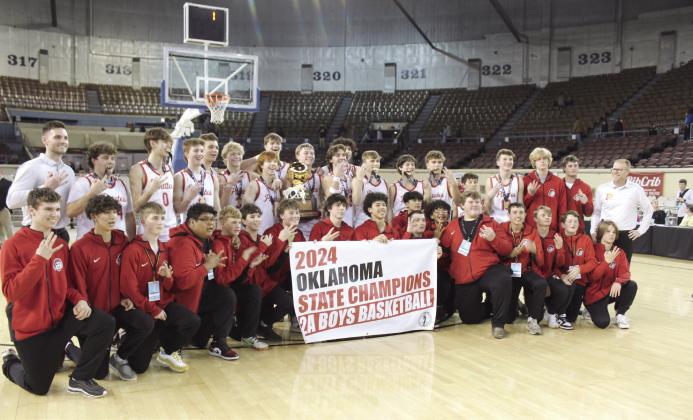 The Dale Pirates and their coaches Reed Johnson, far left, and Jeff Edmonson, far right, pose with their golden trophy after winning the Class 2A Boys State Basketball Tournament Finals for the third straight year on March 9.