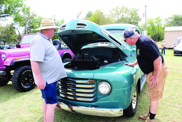 Richard Carter, left, shows his brother Dean Carter the original flathead V-8 in his 1948 Ford F-1 pickup truck during the Frontier Days Car Show, held in the lot at Washington and 4th Street, on Sept. 28. Countywide &amp; Sun/Natasha Dunagan