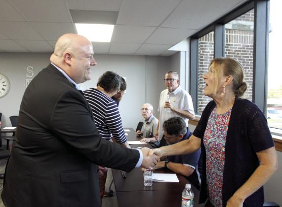 Dr. Stephen Haynes shakes hands with Shawnee Board of Education member Jeanne Swinney following the June 24 meeting. Haynes was hired as the new Sequoyah Elementary Principal. Countywide &amp; Sun/ Natasha Dunagan