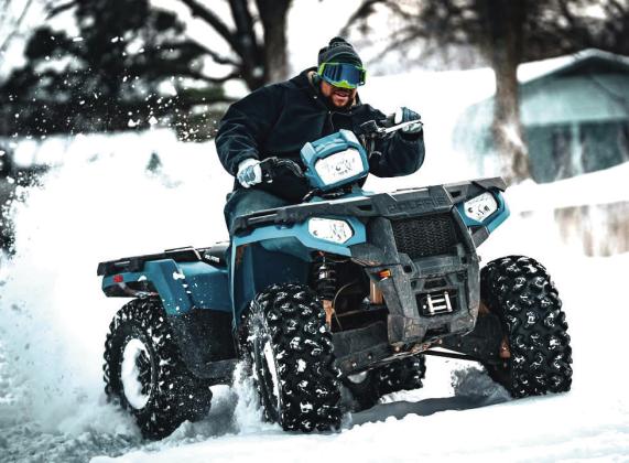 Mikayla Lorenzen captures Bryce Talton in snow-filled action on his four-wheeler. Talton spent the day playing in the snow and pulling neighborhood kids around on sleds in Dunbar Heights.
