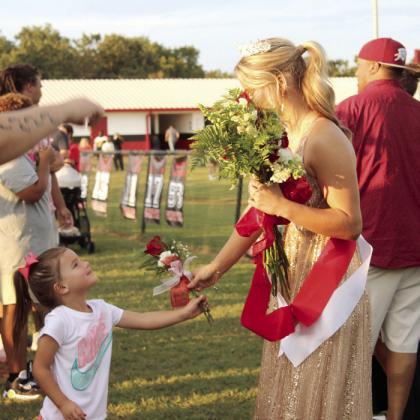 Natasha Dunagan, Countywide &amp;amp; Sun McLoud Fall Homecoming Queen Addison Adams shares a bouquet with her cousin, Leighton Barkhimer, 4, before the game.