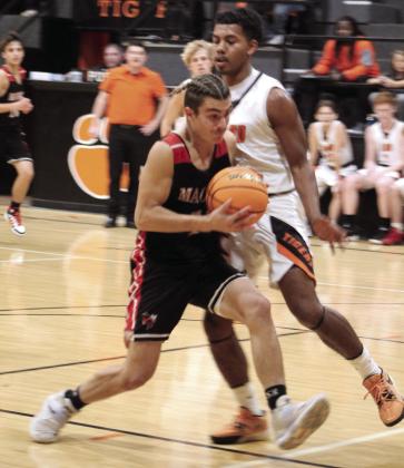Macomb’s Cameron Richardson prepares to shoot for two, as Maud’s Vcake Wassana-Street plays defense during the second half of the Maud home game on Nov. 29. The Maud Tigers won 78-36, and the Lady Tigers won, as well, 56-26.