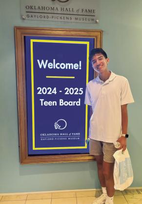 Shawnee High School senior Ahlijah Gipp stands by a sign welcoming the Oklahoma Hall of Fame Teen Board members from across the state. Gipp was the only student from Pottawatomie County to be chosen for the board. Photo provided.