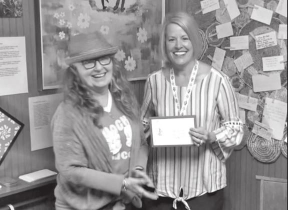 Retired RSU English professor Roxann Yates presents the first-place award in the Oklahoma Poetry Contest to Tecumseh fifth-grade teacher Cody Swinson on April 16. Photo provided.