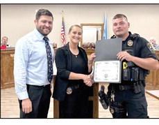 Deputy Lt. Dakota Black (center) presents McLoud officer Marshall Jones (right) with a Distinguished Service Award for their response and action during a tragic incident in April. Also in the photo is Mayor Daniel McClure (left). Julie Talton, Countywide &amp;amp; Sun