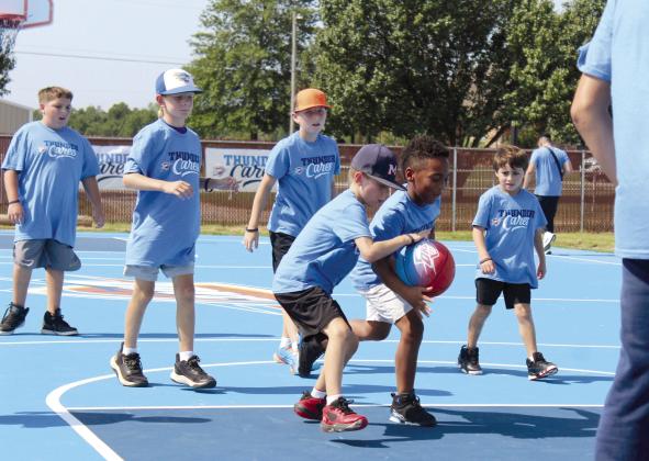 Jeremiah Butts, 7, of Bethel, steals the ball as others watch in a game following the ribbon-cutting for the newly-refurbished Bethel Acres "Thunder" Community Court, located at 18101 Bethel Road, on July 15. The court was resurfaced and repainted, and the nets were replaced, through an OKC Thunder Cares Grant, in conjunction with OG&amp;E. Butts' father said his son has practiced at the court before it was refurbished. Countywide &amp; Sun/Natasha Dunagan