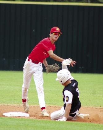 Tecumseh’s Jaxson Douglas slides into second base as Dale Pirates player Riglee Sheppard throws to first during the junior summer games of the John (Rocky) Barrett Classic held at Tecumseh High School on June 20.