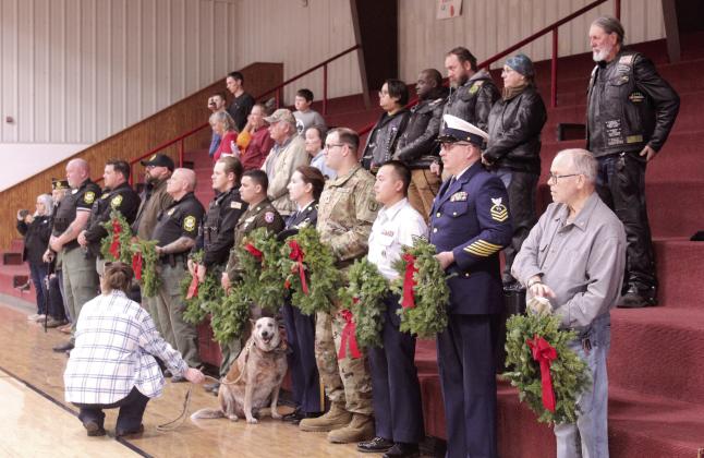 A line of veterans, Sheriff's deputies and a Gold Star father, David Hendrickson, far right, prepare to place wreaths in honor of those lost in each military branch, POW-MIAs, and Gold Star Families during the Wreaths Across America Ceremony, held at Macomb High School gymnasium on Dec. 13. Also shown are members of the Rolling Ambassadors motorcycle club who would place wreaths on the graves of veterans at Prairie View and Romulus cemeteries following the event. See full cutline below.