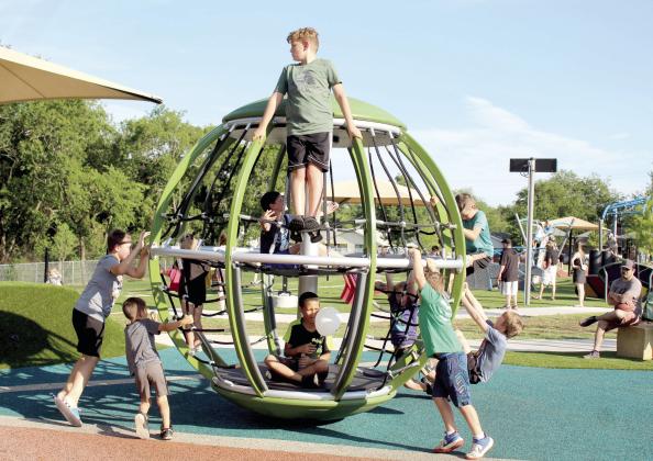 About 10 boys ride on the spinning orb during the KidSpace Park Grand Opening, June 23. Hundreds of people attended the event, which continued on June 24. Countywide &amp; Sun/Natasha Dunagan