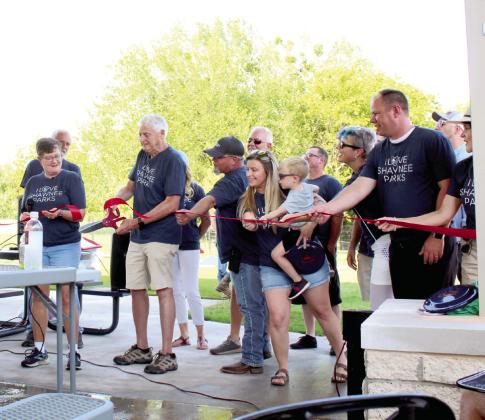 Held up by several City of Shawnee employees, the ribbon is cut by Shawnee Mayor Ed Bolt during the KidSpace Park Grand Opening, June 23. KidSpace is the first park to be renovated using the half-cent sales tax passed in June 2018.