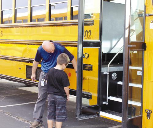 Shawnee Bus Driver Tom Wondrock shows a boy where the charging port of an electric school bus is, during the First United Bank Electric Vehicle Show on Oct. 21. Countywide &amp;amp; Sun/Natasha Dunagan