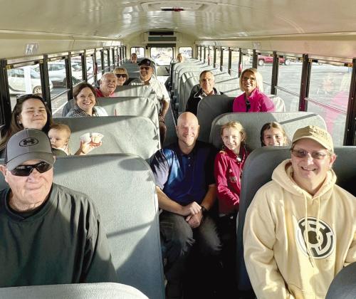 Several people - including Shawnee Mayor Ed Bolt, left fourth seat back, and bus driver Tom Wondrock, center aisle - smile before taking a ride on one of two new Shawnee Public Schools electric buses. The two buses were part of the First United Bank Electric Vehicle Show on Oct. 21. Photo provided by Amanda Johnson.