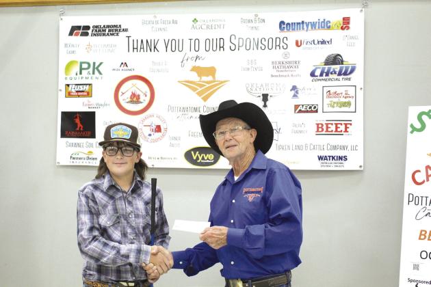 Sawyer Speers, a freshman in Tecumseh at the time, accepts a $900 check for sixth place from Pott. Co. Cattlemen’s Association President Bob Freeman in the 2022 Beef Quiz Bowl. Speers used his winnings to buy a Commercial bred heifer and will show the calf at the Pottawatomie County Junior Livestock Show, March 6. File photo.