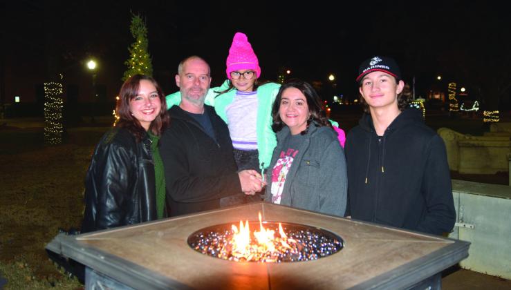 The Tosh family (from left): Kenzi, Mike, Emma, SeLinda and Michael, stopped by the standing fire pits placed around the Oval at the Gingerbread Village event by Habitat for Humanity hosted by OBU on Dec. 14. Countywide &amp; Sun/Julie Talton