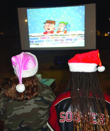 An outdoor movie played allowing patrons to sit on the lawn with provided picnic blankets at the Gingerbread Village event.