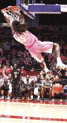 Potawatomi Fire forward Jay Hedgeman swings from the basket while making a slam dunk during the April 9 home game against the Enid Outlaws. Hedgeman tipped in 22 of the 125 total Fire points.