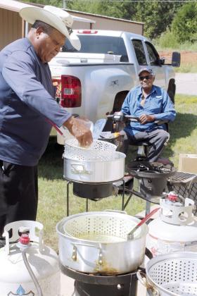 Frank Phillips batters and fries catfish outside the Brooksville Community Center, as his brother Leonard Phillips watches, during a fish fry fund-raiser on Aug. 23. Phillips caught about 150 pounds of catfish for the fund-raiser, which benefitted a new restroom at the Brooksville Cemetery. So far, the framework has been built for the restroom, and Brooksville Mayor Charles Carthen said, in addition to mens' and womens' restrooms, it will have a sitting area.