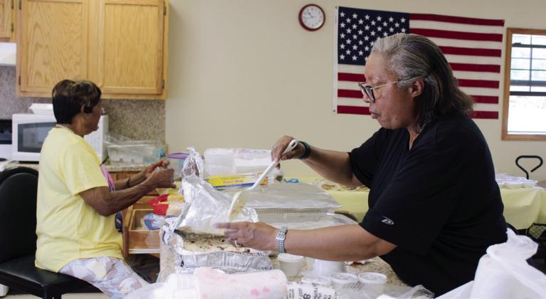 Earnie Carthen plastic wraps cornbread and Beverly Cooks dishes up coleslaw during a fish fry at the Brooksville Community Center on Aug. 23. Frank Phillips caught about 150 pounds of catfish for the fund-raiser, which benefitted a new restroom at the Brooksville Cemetery. So far, the framework has been built for the restroom, and Brooksville Mayor Charles Carthen said, in addition to mens and womens restrooms, it will have a sitting area.