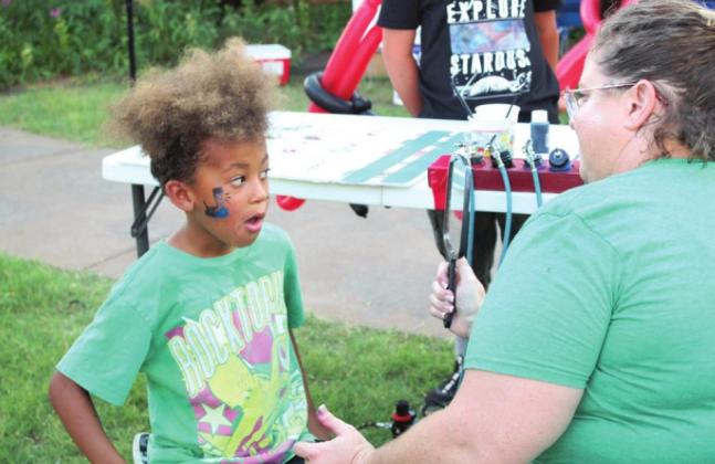 Amanda Biffel, of the India Shriners, shows Corvus Bradford, 6, of Shawnee, his air-brushed face painting at the Blues on Broadway event, in downtown Shawnee, on June 18. Countywide &amp; Sun/Natasha Dunagan