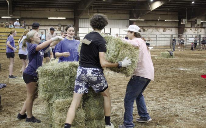 The North Rock Creek FFA Team #2 works together to stack hale bales during the team relay races at the 13th Annual Farmhand Olympics on Sept. 7. Shown, from left, are Berklee Gossen, Addyson Troxel, Alex Andrews and Stephen Wickerd. File photo