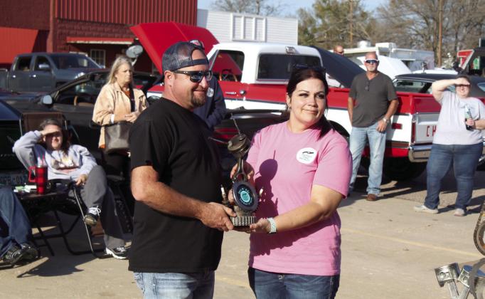 Adam Wilson accepts the 2nd Best of Show trophy from Michelle Oakley, founder and director of Southern Paws Rescue, Inc., for his 1972 Chevy C-10. A second Best of Show trophy was presented to Bob Shay, of Ada, for his 1965 Buick.