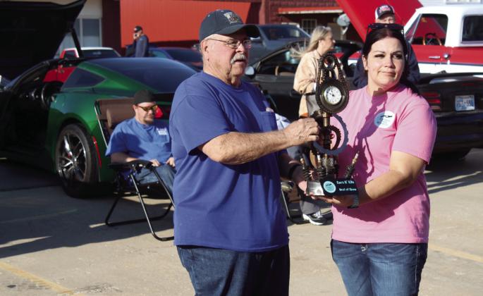 Bob Shay, of Ada, accepts the Best of Show trophy from Michelle Oakley, founder and director of Southern Paws Rescue, Inc. for his 1965 Buick. A second Best of Show trophy was presented to Adam Wilson for his 1972 Chevy C-10.