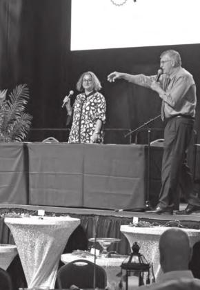 Auctioneer Mike Matlock (right) takes bids during Project: SAFE’s 13th Annual Honey Do Action, Oct. 1, as Project: SAFE Executive Director Renée Clemmons watches (center). Countywide &amp;amp; Sun/Kendra Johnson