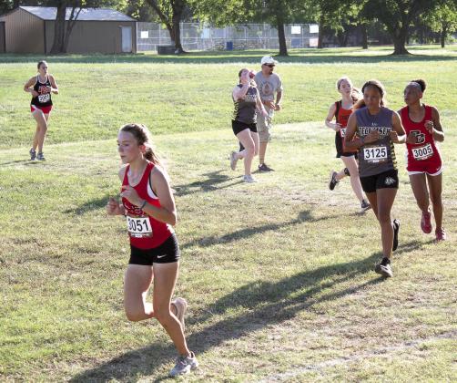North Rock Creek junior Aubree Gonzales (#3051) and Tecumseh sophomore Aaliyah Stargell (#3125) run in the Tecumseh Cross Country Meet on Sept. 22. There were 60 girls competing.