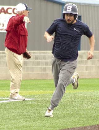 Shawnee Alum Bill Ford points the way as fellow alum Michael Chavez rounds third on his way home during the SHS Alumni Baseball Game on April 25.