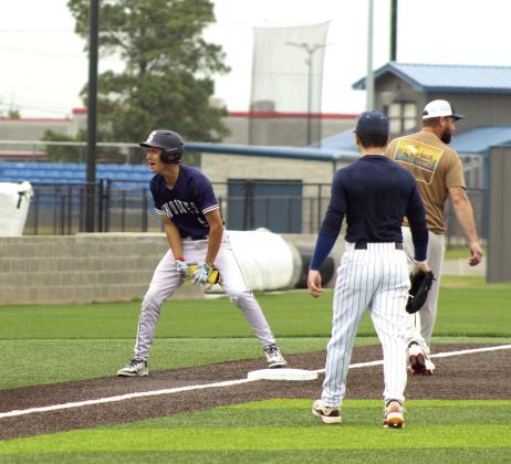 Shawnee sophomore Parker Wells celebrates after hitting a triple during the Shawnee High School Alumni Game on April 25. Also shown are alums, pitcher Eli Davis and third baseman Gunner Wright.