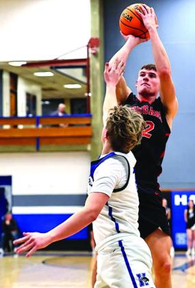 North Rock Creek's Landon Rosser shoots over the Harrah defender in the game on Jan 20. NRC boys won 73-37. The girls' game was postponed due to multiple players contracting the flu.