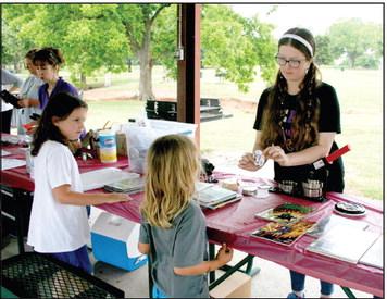 Kaitlyn Love, long time helper of the Summer Reading Challenge, creates custom comic book buttons for kids at Slick Humphrey Park, hosted by the Tecumseh Public Library. Countywide &amp;amp; Sun/Valerie Scott
