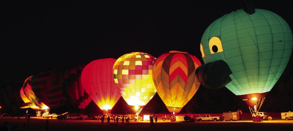 A line of hot air balloons light up on Aug.9, including one shaped like a llama, during the FireLake Fireflight Balloon Festival at the CPN Festival Grounds. As in the past few years, there were 25 balloons from all over the U.S., but they were unable to offer rides this year due to the wind speeds. Photos By Natasha Dunagan, Countywide &amp;amp; Sun