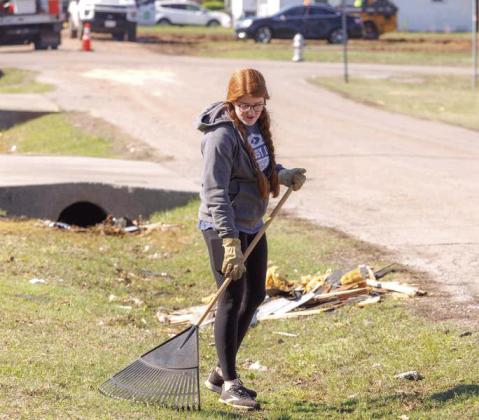 An Oklahoma Baptist University student rakes debris after a tornado tore through the area April 19. Photo provided