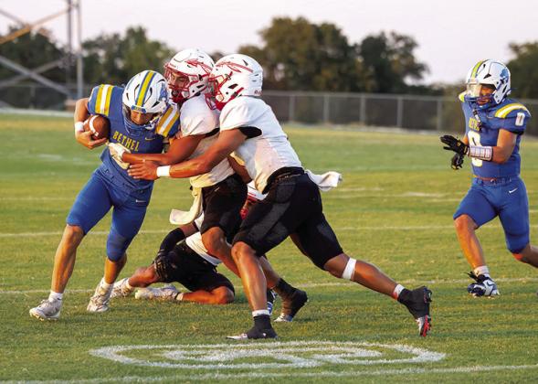 Bethel junior Maddox Davis carries the ball as two McLoud players work to bring him down. Photo courtesy of Richelle Treece