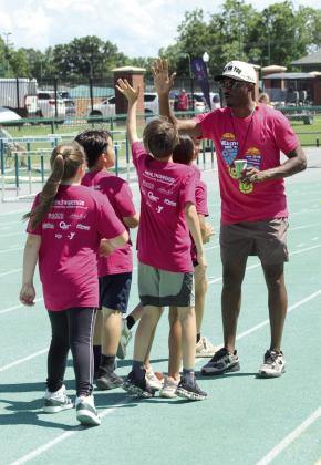 Charles Clark, gives high fives all around after a race at the Health Week Track Clinic, held at Oklahoma Baptist University on May 28.