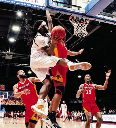 Potawatomi Fire’s #8 KD Moore flies under the basket for a shot against three contenders. Photo courtesy of Potawatomi Fire/Landon Kidney