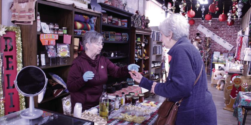 Martha Hernandez offers a sample of non-alcoholic white grape juice from Arkansas to Jan Garrison of Shawnee. Hernandez is the mother of business owner Christina Hernandez. She also had samples of foods sourced from Oklahoma companies. Natasha Dunagan, Countywide &amp;amp; Sun