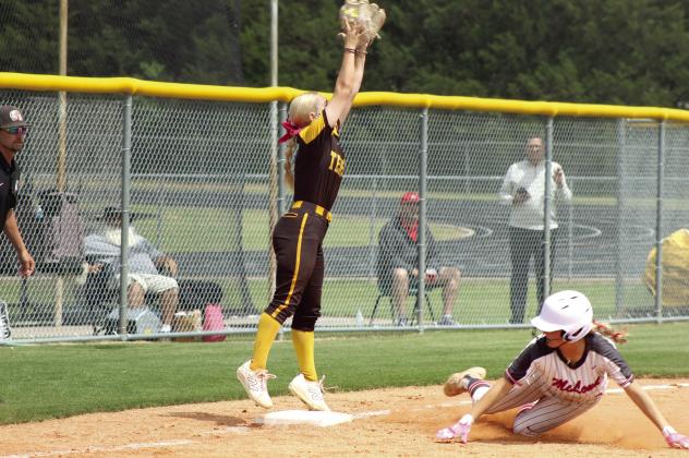 Tecumseh senior Blakelee Parker reaches high for the catch, as McLoud junior Ella Smith slides into third base, during the April 29 Class 5A Slow Pitch Regional Tournament game at Tecumseh. The Lady Savages won that game, 4-3, and the earlier game with Guthrie, 8-3, to become Regional Champions. Photos by Natasha Dunagan, Countywide &amp;amp; Sun