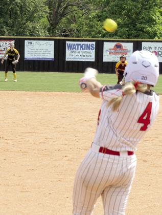 McLoud junior Ella Smith gets a hit, as Tecumseh's Josie Walker and Cadence Leba wait to catch it.