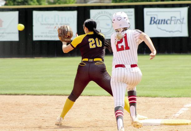 Tecumseh junior Jacee Townsend makes the catch as McLoud junior Lexi Patterson approaches first base on April 29.