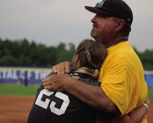 Tecumseh Slow Pitch Head Coach Perry Wilson gets a hug from junior Alyssa Norton during the medal ceremony after winning the Class 5A Slow Pitch State Championships on April 30. Countywide &amp; Sun/Natasha Dunagan