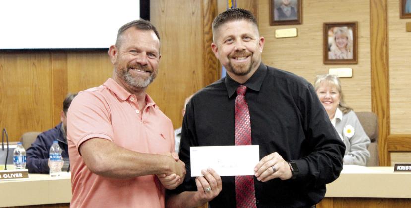 Community Renewal representative Brandon Dyer, left, presents a donation for $45,000 to Shawnee Public Schools Superintendent Dr. Aaron Espolt during the Dec. 4 Board of Education meeting. Dyer said part of the donation came from the band, Foreigner, when they played a concert in Shawnee. Countywide &amp; Sun/Natasha Dunagan