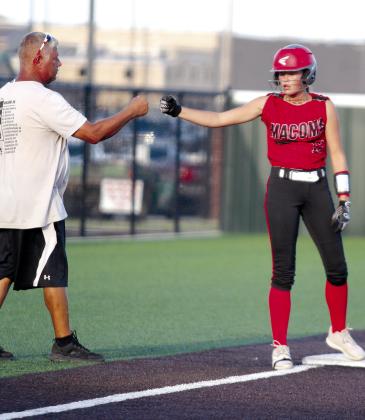 Macomb freshman Addy Beauchamp gets a fist bump from Head Coach Jimmy Hancock after hitting a triple in the second inning of the Aug. 16 game against New Lima.
