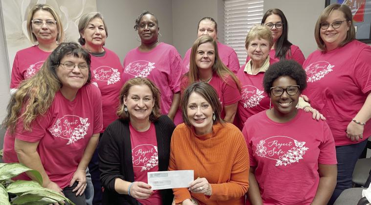 Surrounded by Project: SAFE staff, Renee Clemmons, Project: SAFE Executive Director, is presented a grant check by Kathy Laster, President &amp;amp; CEO of the Avedis Foundation. Photo provided