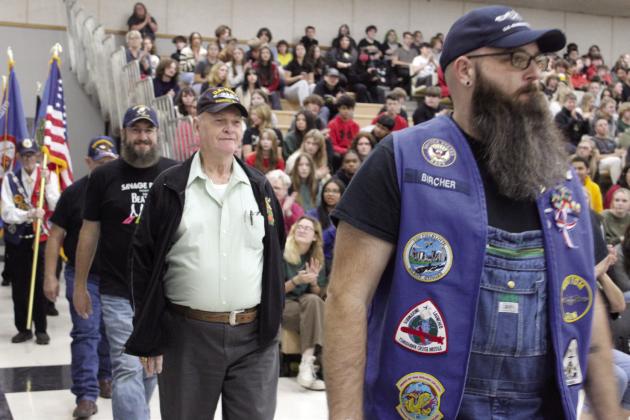 Navy veterans, from left, Philip Wolke, Charles Spillers and Becket Bircher walk in the Veterans Parade at the Tecumseh High School Veterans Day Assembly on Nov. 10. There were about 30 veterans who walked in the parade and were applauded as they lined up in front of the audience. There were also pictures of around 40 veterans, who were related to students and staff, shown in a slide show throughout the event. Countywide &amp; Sun/Natasha Dunagan