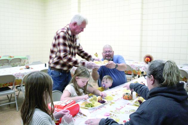 Matt Goodson serves a family at the 19th Annual Tecumseh Family Thanksgiving Dinner, held at Tecumseh City Hall Auditorium on Nov. 28. Goodson said his wife, Rita, was also volunteering.